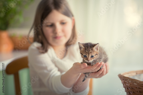 Girl holding kitten in hands at home