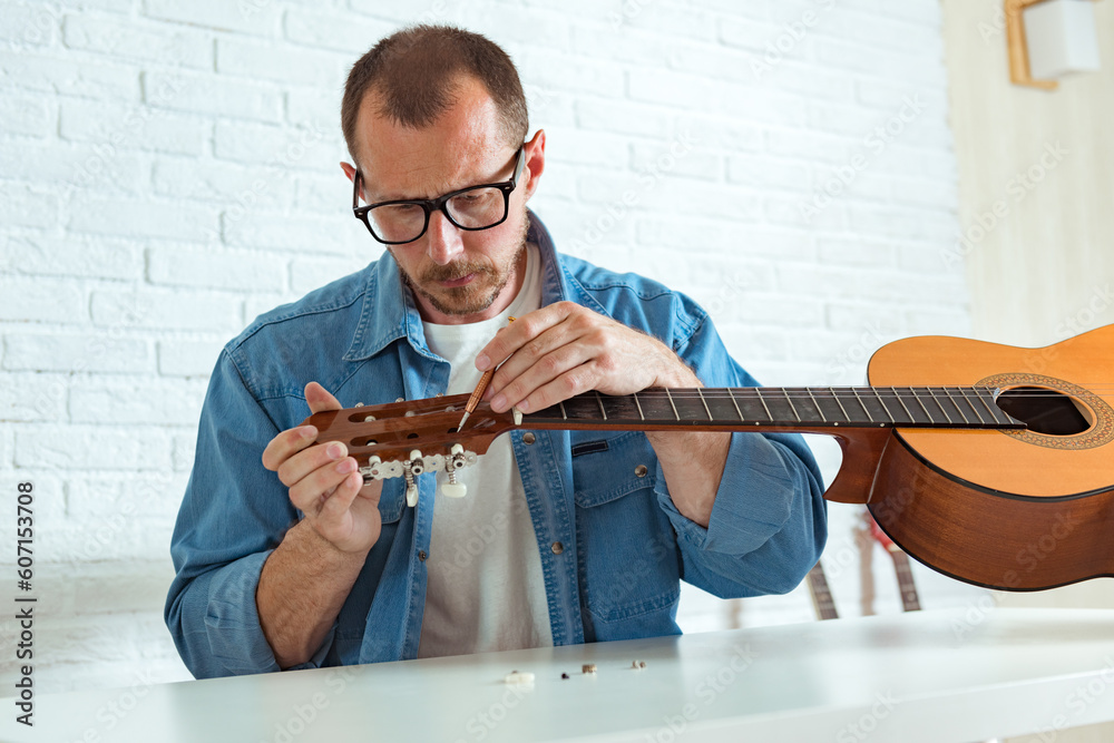Checking the acoustic guitar string, repair of guitar pegs. Expert is