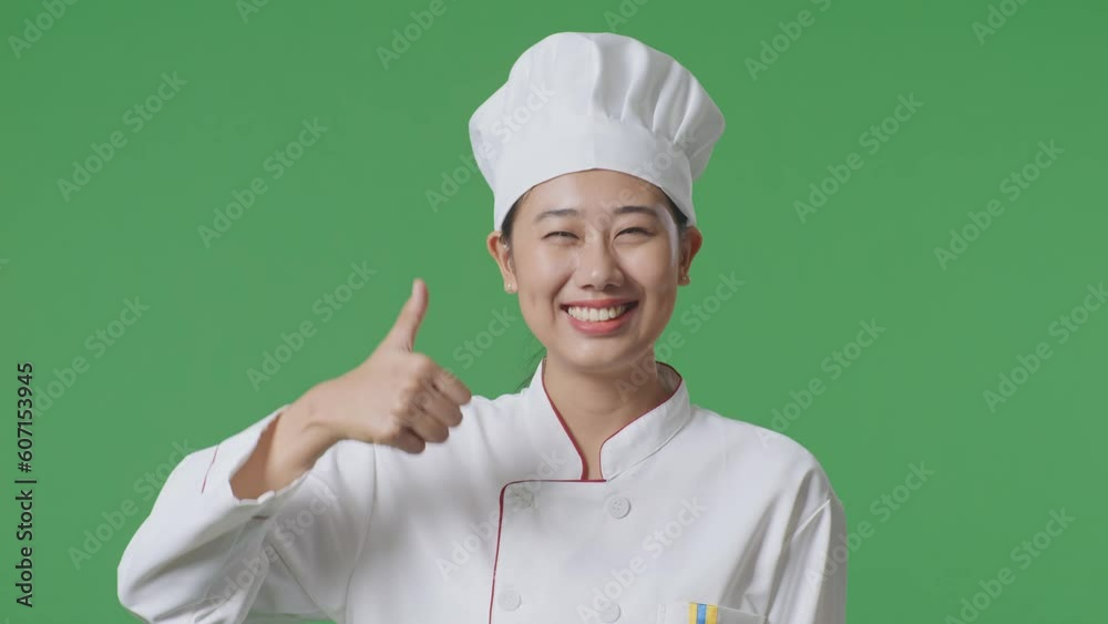 Close Up Of Asian Woman Chef Smiling And Showing Thumbs Up Gesture To Camera While Standing In The Green Screen Background Studio
Close Up Of Asian Woman Chef Smiling And Showing Thumbs Up Gesture To Camera While Standing In The Green Screen Background Studio