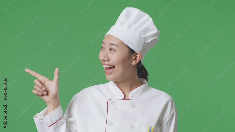 Close Up Of Asian Woman Chef Smiling And Pointing To Side While Standing In The Green Screen Background Studio
Close Up Of Asian Woman Chef Smiling And Pointing To Side While Standing In The Green Screen Background Studio