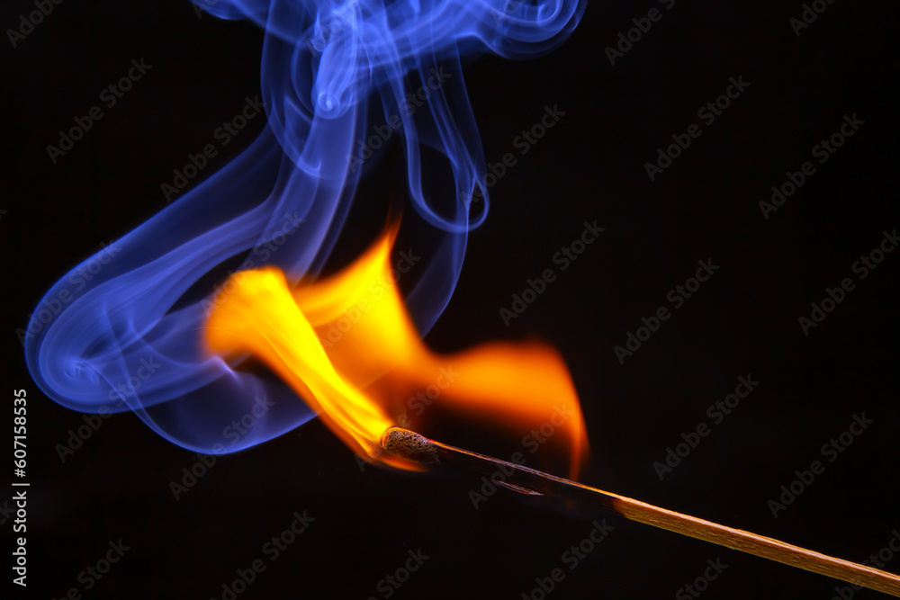 Flashed and burning wooden match on a dark background close-up. Bright fire and smoke from a burning tree. Flashed and burning wooden match on a dark background close-up. Bright fire and smoke from a burning tree.