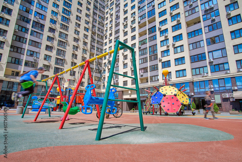 Children's playground with swings on the territory of the residential complex.