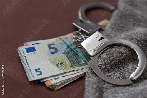 silver handcuffs on many large euro notes