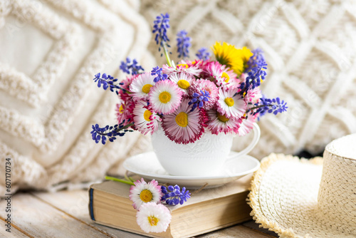 Countryside decor  old book  wooden background  straw hat. Greeting postcard with bright summer or spring flowers in a cute cup. Congratulations for Mother s or Women s day  birthday or anniversary