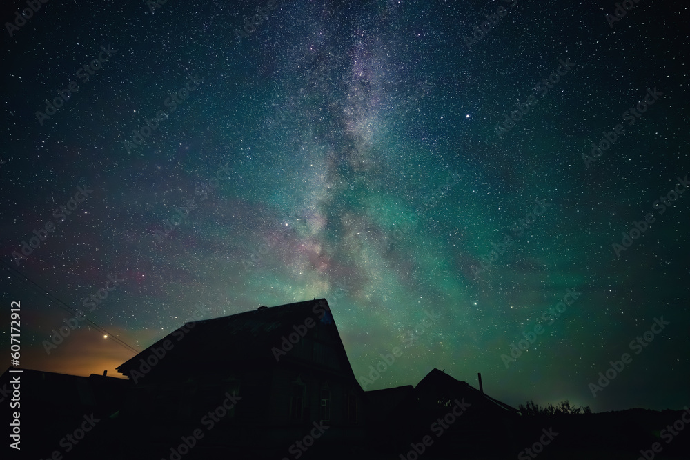Stars sky and milky way above roofs in countryside Stars sky and milky way above roofs in countryside