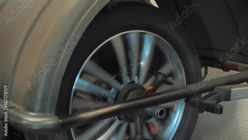 Tire. Car service. In the auto service, an employee performs wheel balancing after installing a new tire on the car rim using specialized equipment. A technical process ensuring smoothness and photo