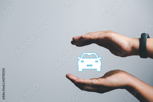 Business woman's hand protecting white icon car on desk. Planning to manage transportation finance costs. Concept of car insurance business, saving buy - sale with tax and loan for new car.