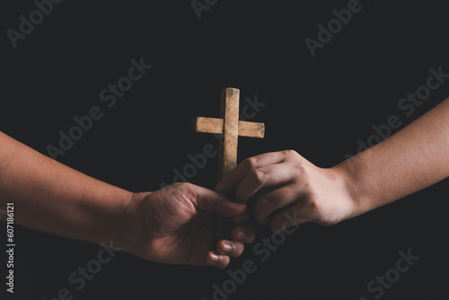 Woman's hand with cross. Concept of hope, faith, christianity, religion, church online. Person holding christian cross to making pray indoors. Believe and faith for christian people.
