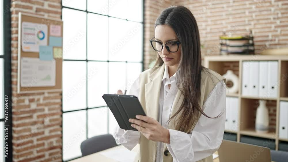 Young beautiful hispanic woman business worker using touchpad with doubt expression at office Young beautiful hispanic woman business worker using touchpad with doubt expression at office