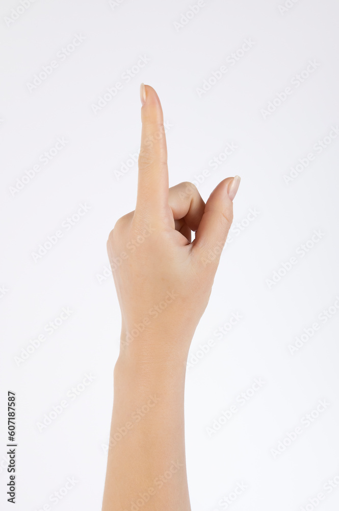 Female hand with raised index finger up on a white background. Female hand with raised index finger up on a white background.