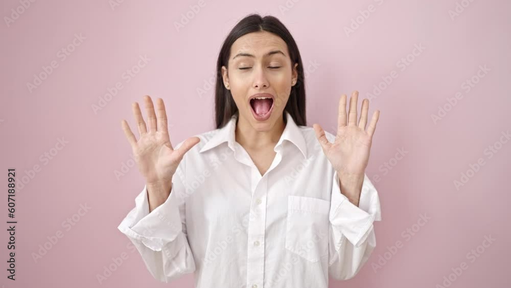 Young beautiful hispanic woman standing with surprise expression over isolated pink background Young beautiful hispanic woman standing with surprise expression over isolated pink background