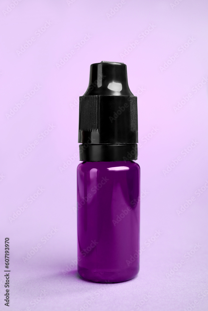 Bottle with purple food coloring on bright background