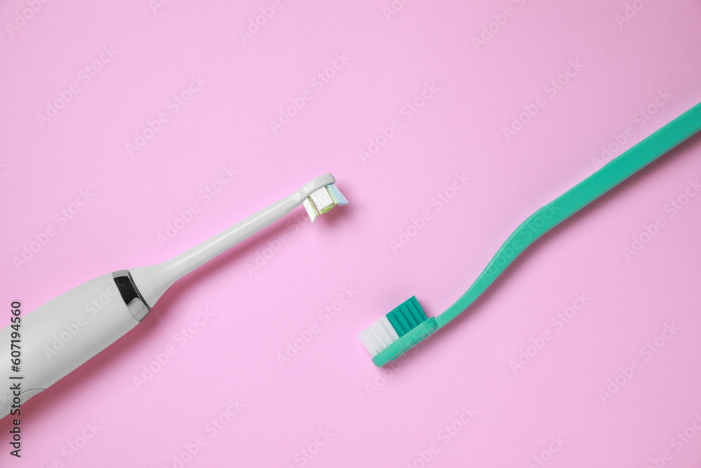 Electric and plastic toothbrushes on pink background, flat lay Electric and plastic toothbrushes on pink background, flat lay