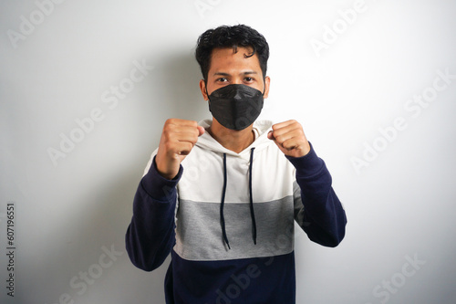 Asian man wear hygienic mask and post Boxing guard action for fight the disease