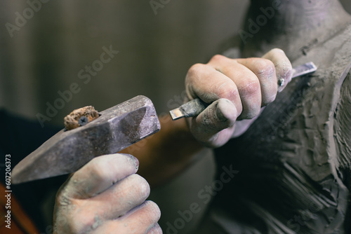 Person holding gray metal sculpting tool photo