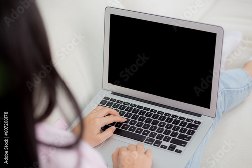 Young asian woman work from home with laptop computer blank screen mockup, freelance is female using notebook with display empty, girl typing keyboard, business and communication concept.