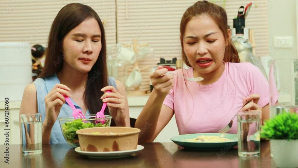 Daily life of two young Asian women who live together in a house : Delicious dinner sitting together on a salad and spaghetti dinner on the kitchen table : Relationship of best friends and take care. Daily life of two young Asian women who live together in a house : Delicious dinner sitting together on a salad and spaghetti dinner on the kitchen table : Relationship of best friends and take care.