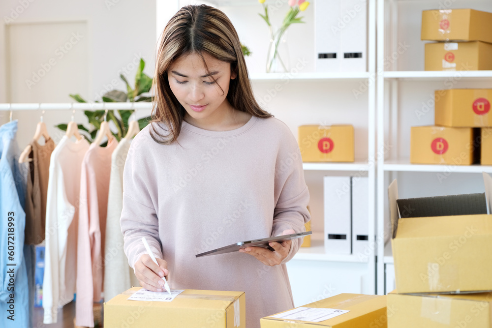 Small business owner checking product stock by digital tablet at home office Small business owner checking product stock by digital tablet at home office