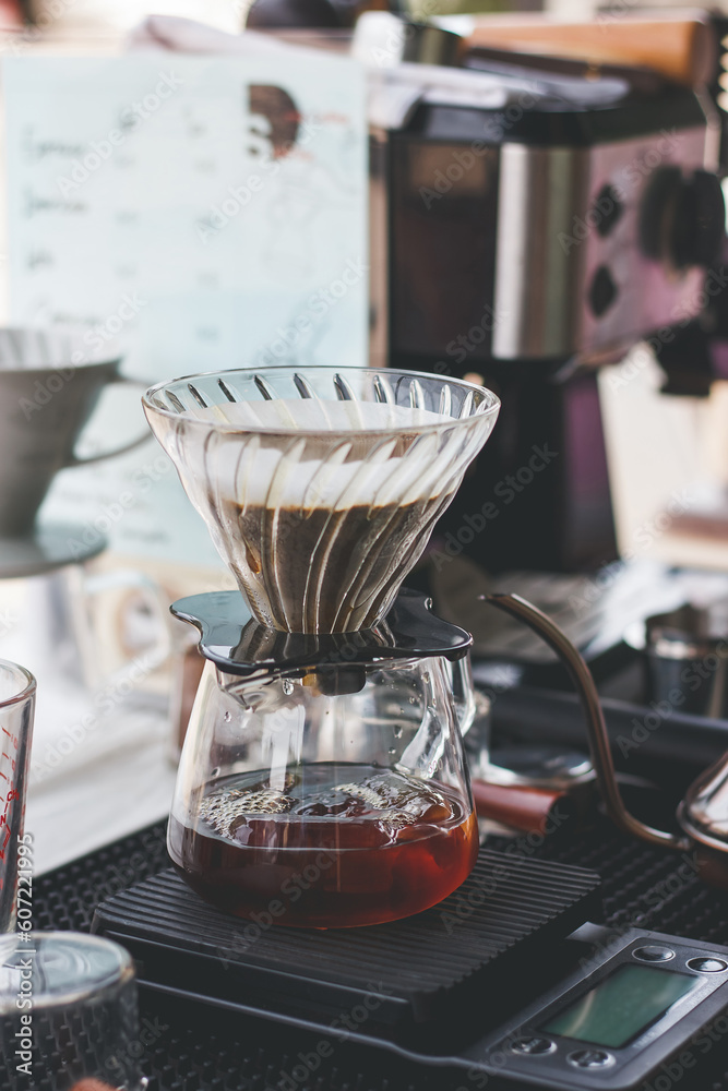 Alternative coffee brewing method, using pour over dripper and paper filter, coffee brewing gadgets on bar counter in cafe, close up view