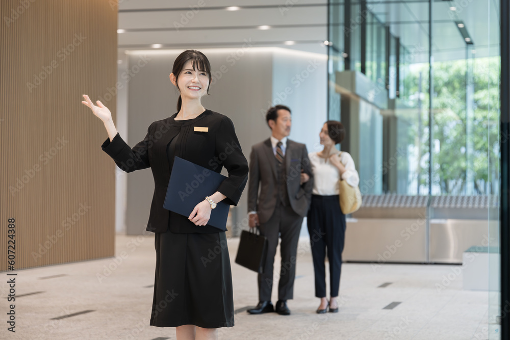 受付、コンシェルジュ、ホテルのフロントなどで案内する接客業の女性のイメージ 受付、コンシェルジュ、ホテルのフロントなどで案内する接客業の女性のイメージ