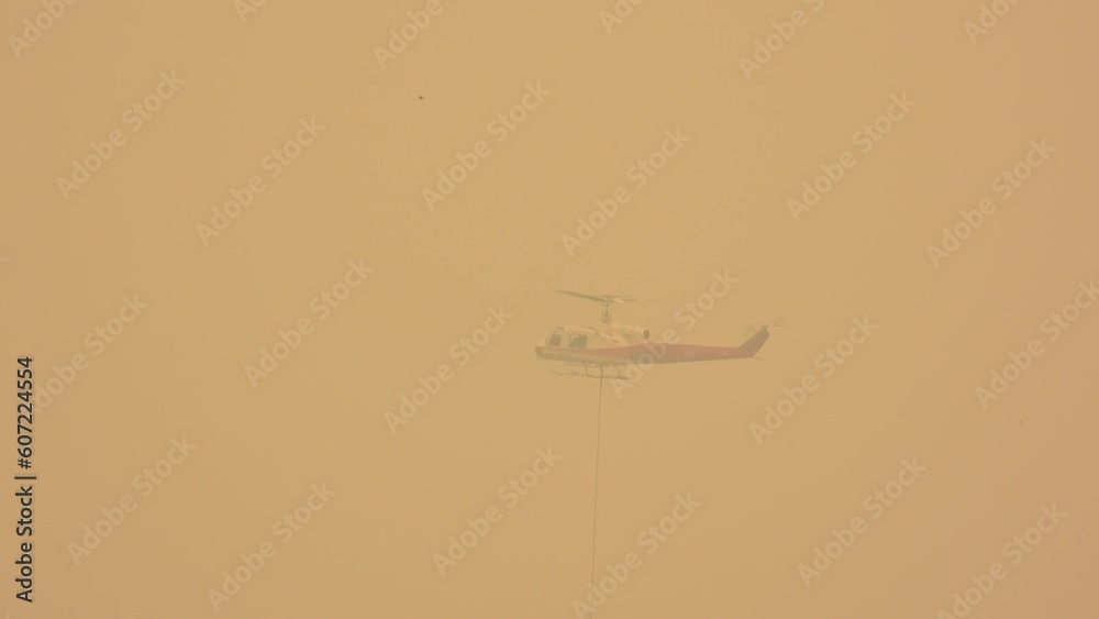 Helicopter Flying Through Thick Smoke Unloading Water in Wildfires of Alberta, Canada. Helicopter Flying Through Thick Smoke Unloading Water in Wildfires of Alberta, Canada.