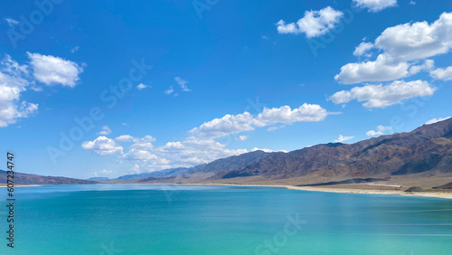 Beautiful summer landscape. Amazing panorama of a mountain lake. Blue sky and white clouds.
