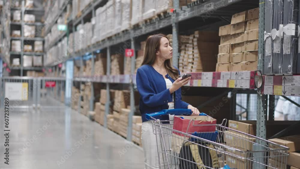 Asian woman using telephone looking up stock taking inventory in warehouse shopping. logistic industry and business import export. Asian woman using telephone looking up stock taking inventory in warehouse shopping. logistic industry and business import export.