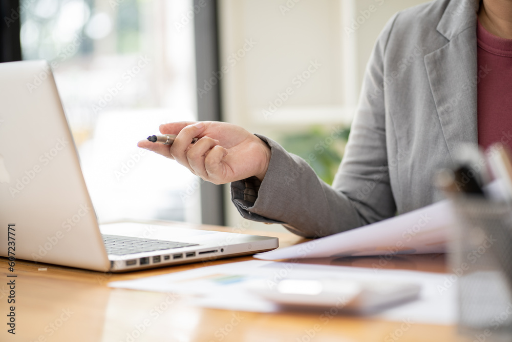 Businesswoman Accountant analyzing investment charts Invoice and pressing calculator buttons over documents. Accounting Bookkeeper Clerk Bank Advisor And Auditor Concept Businesswoman Accountant analyzing investment charts Invoice and pressing calculator buttons over documents. Accounting Bookkeeper Clerk Bank Advisor And Auditor Concept