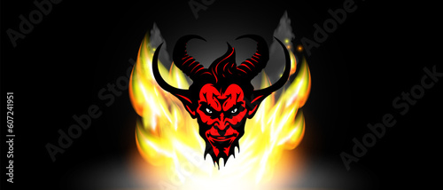 Vector graphic cartoon red and black horned scary disgusting devil or satan head against a background of bright flames.