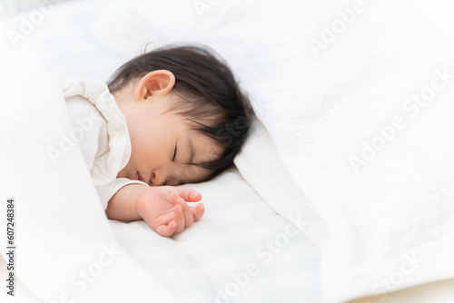 Fotografia ベッドで昼寝する生後9ヶ月の赤ちゃん