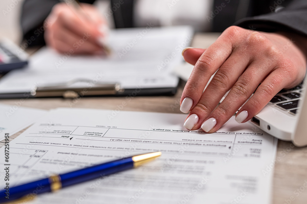 closeup woman filling 1040 tax form at office closeup woman filling 1040 tax form at office