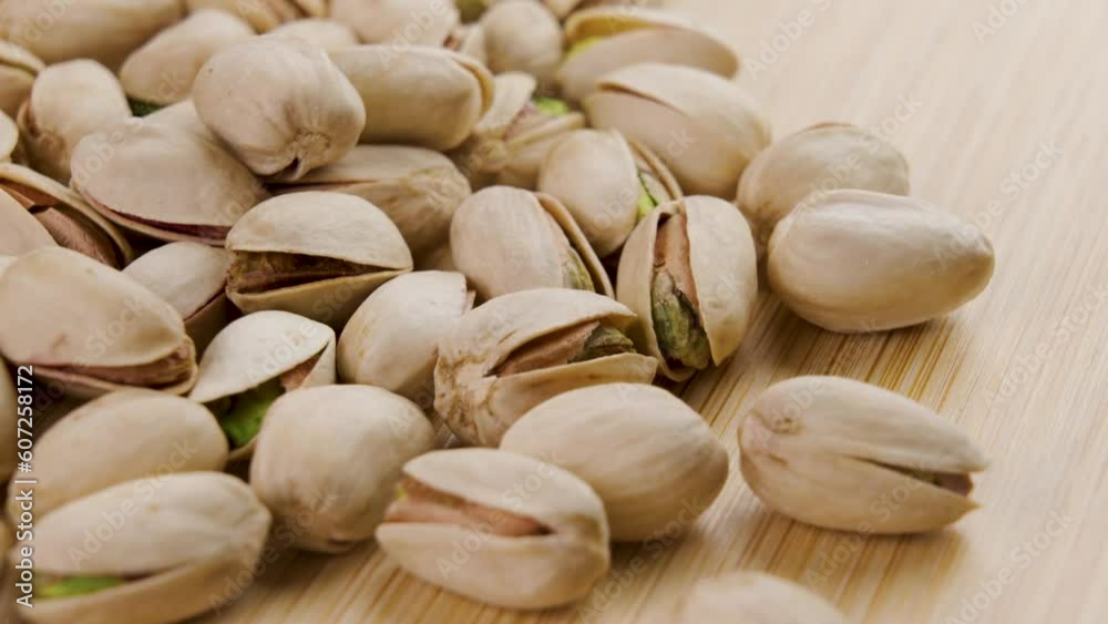 Dried pistachio nuts closeup. Rotation. On a wooden surface Dried pistachio nuts closeup. Rotation. On a wooden surface