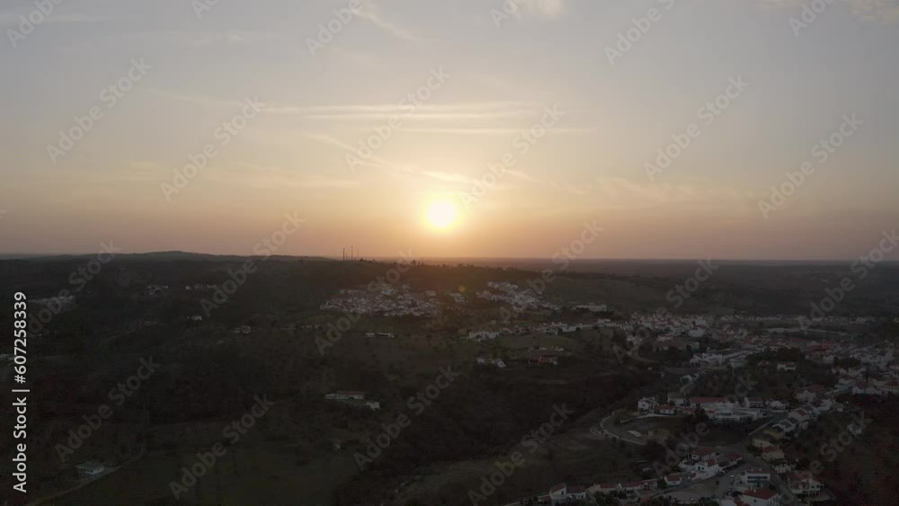dramatic sunset unfolds, a small village nestled in the heart of Alentejo, Portugal, becomes the enchanting focal point, basking in the warm hues of the sky. dramatic sunset unfolds, a small village nestled in the heart of Alentejo, Portugal, becomes the enchanting focal point, basking in the warm hues of the sky.