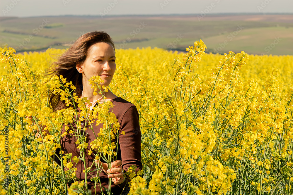 a young woman, of Caucasian race, entered a field of tall, blooming yellow flowers, a rapeseed field, the day was very sunny, bright and warm, the field evoked emotions of delight and admiration a young woman, of Caucasian race, entered a field of tall, blooming yellow flowers, a rapeseed field, the day was very sunny, bright and warm, the field evoked emotions of delight and admiration