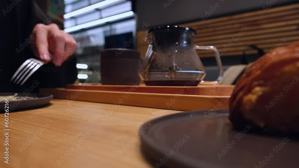 close-up coffee in a decanter brewed v60 in a cafe on a wooden tray between two eating people close-up coffee in a decanter brewed v60 in a cafe on a wooden tray between two eating people