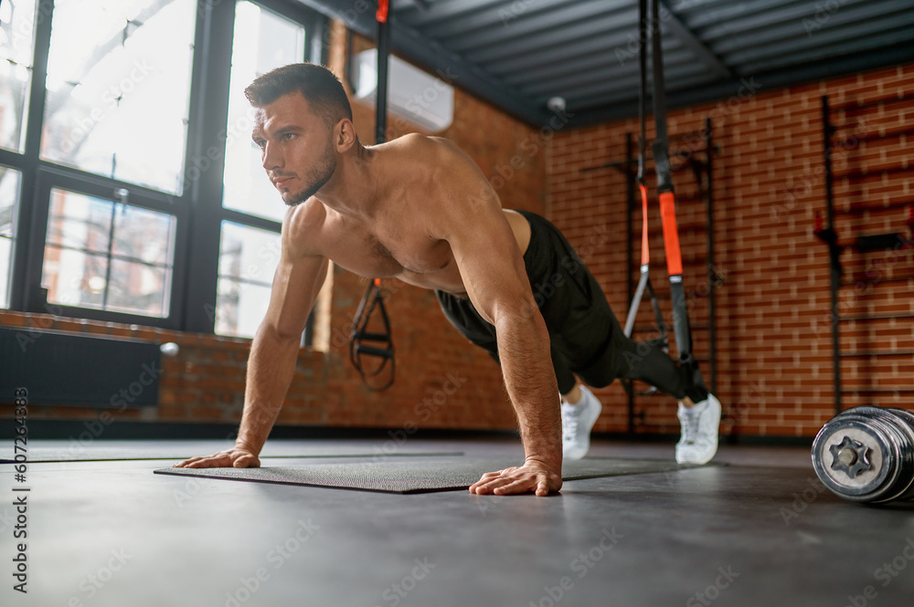 Man standing in plank position on arms
