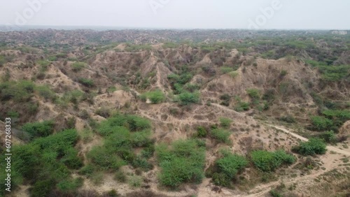 Slow motion aerial view of gully erosions of the iconic badlands of Chambal ravines next to the national highway in Morena Rajasthan Madhya Pradesh border used by dacoits to flee or hide in photo