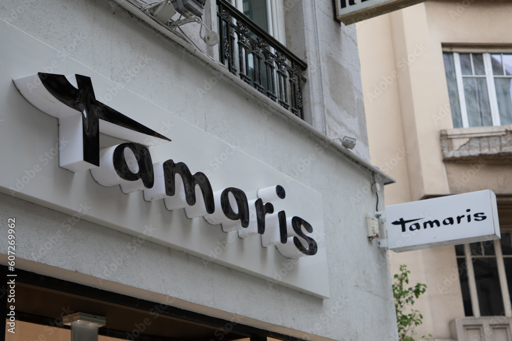 Tamaris logo brand fashion shop and text sign store wall on entrance facade  boutique of footwear company fashion shoes Stock Photo | Adobe Stock