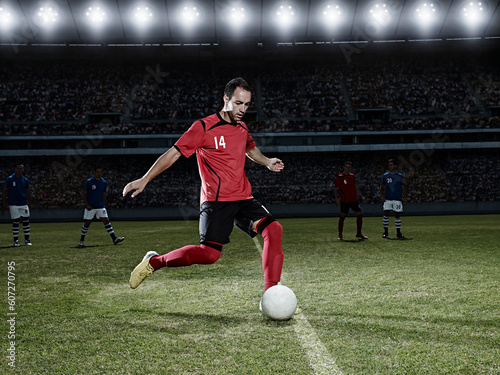 Soccer player kicking ball on field