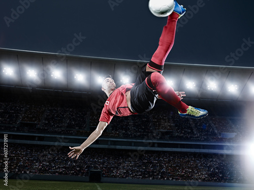 Soccer player kicking ball in mid-air on field photo