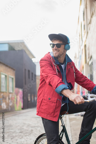 Man riding bicycle on city street © KOTO
