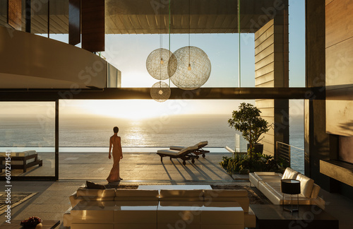 Woman in modern house overlooking ocean