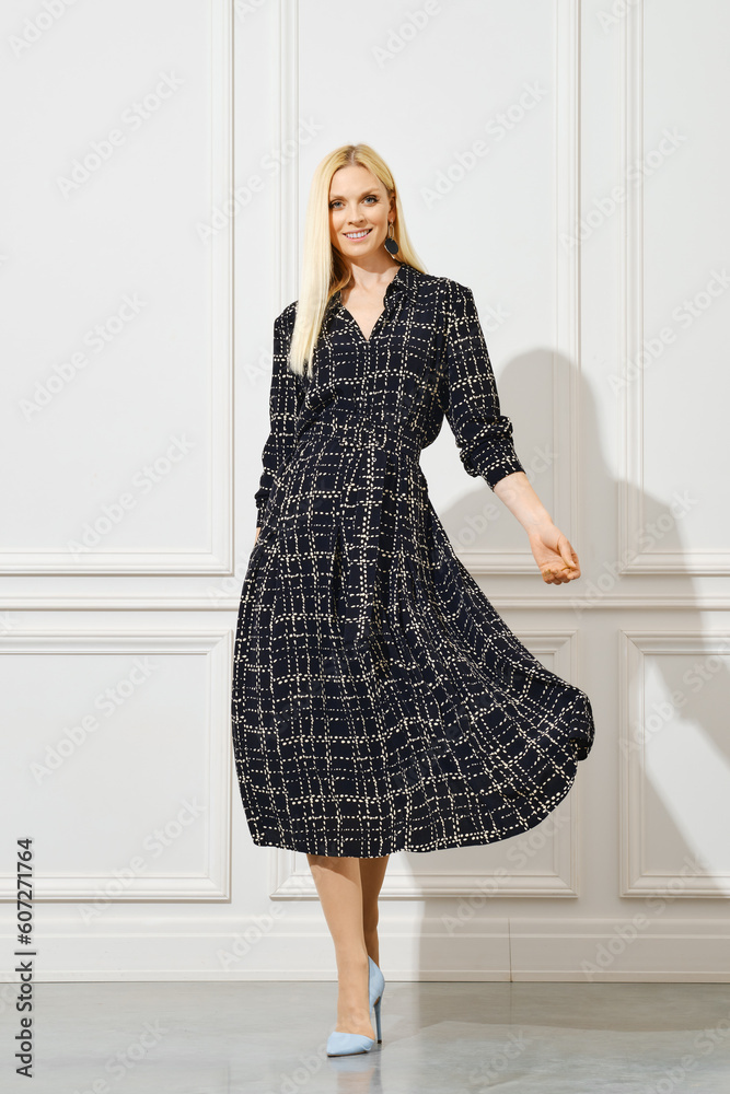 Smiling woman walking in wavy dress Smiling woman walking in wavy dress