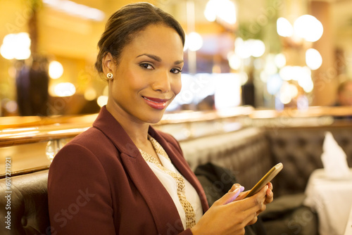 Businesswoman using cell phone in restaurant