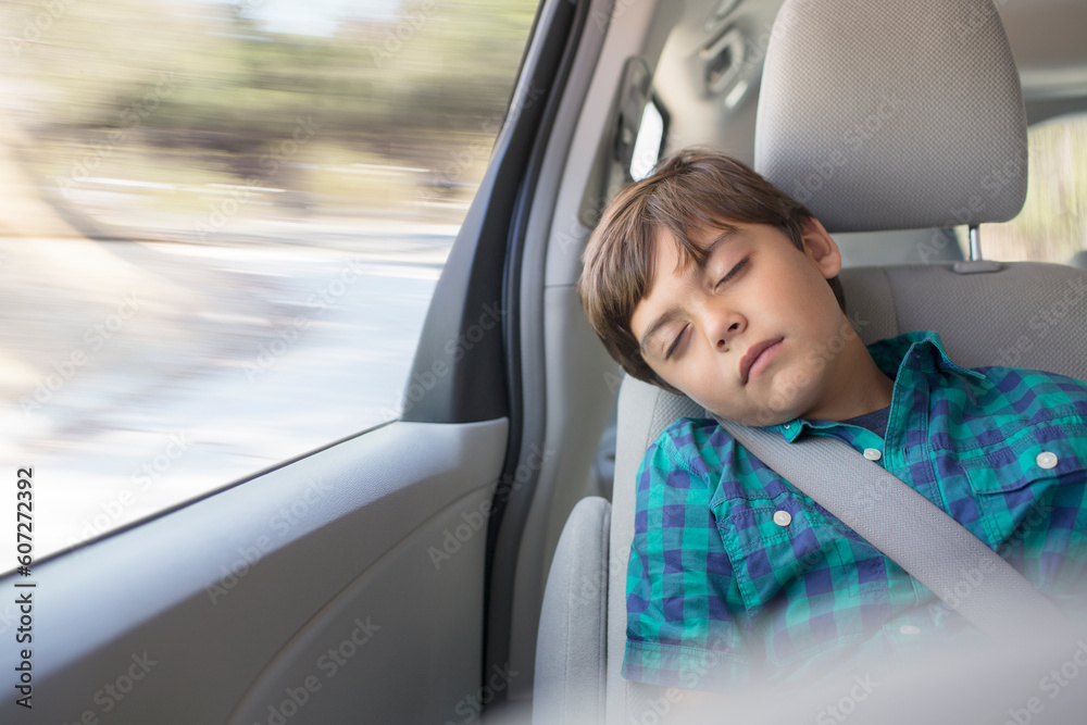 Boy sleeping in back seat of car
