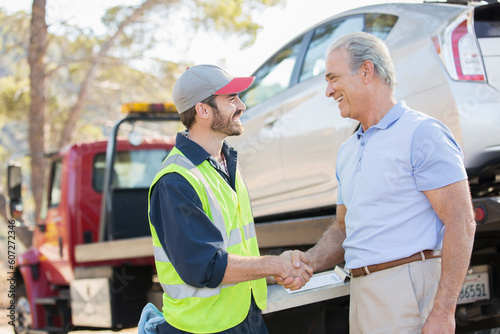 Roadside mechanic and man shaking hands photo