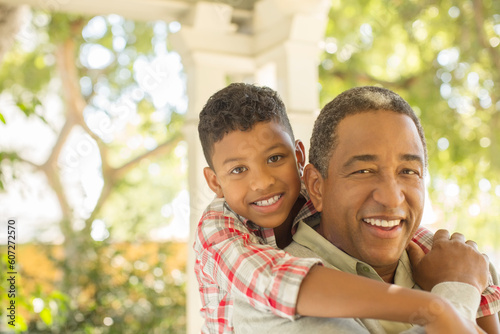 Portrait of smiling grandfather and grandson hugging outdoors