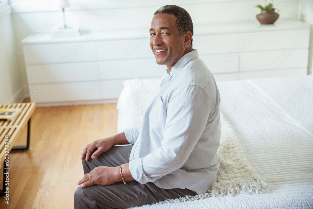 Portrait of smiling senior man sitting at the edge of bed Portrait of smiling senior man sitting at the edge of bed