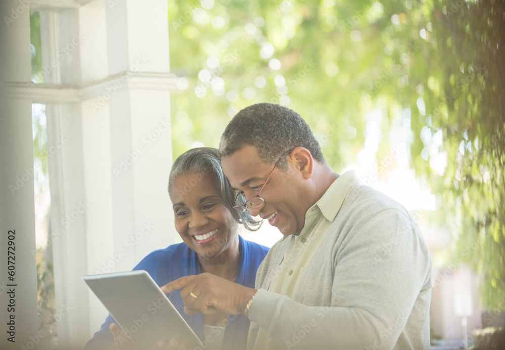 Happy senior couple using digital tablet on porch Happy senior couple using digital tablet on porch