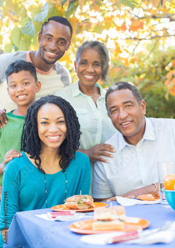 Portrait smiling multi-generation family eating lunch at patio table